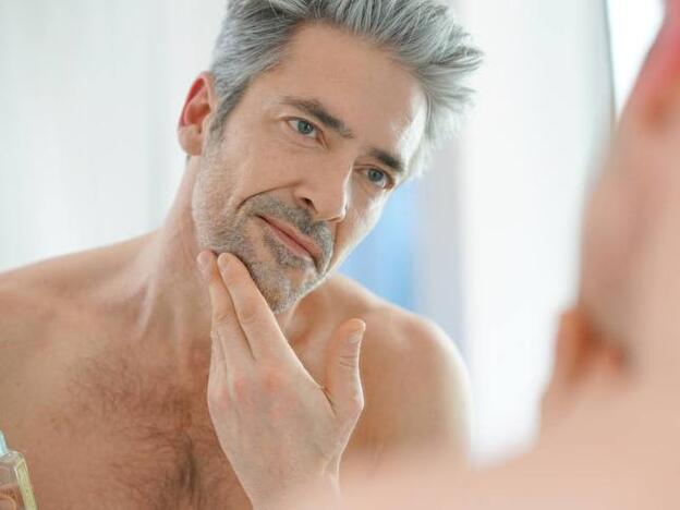 Imagen de hombre maduro revisando su barba
