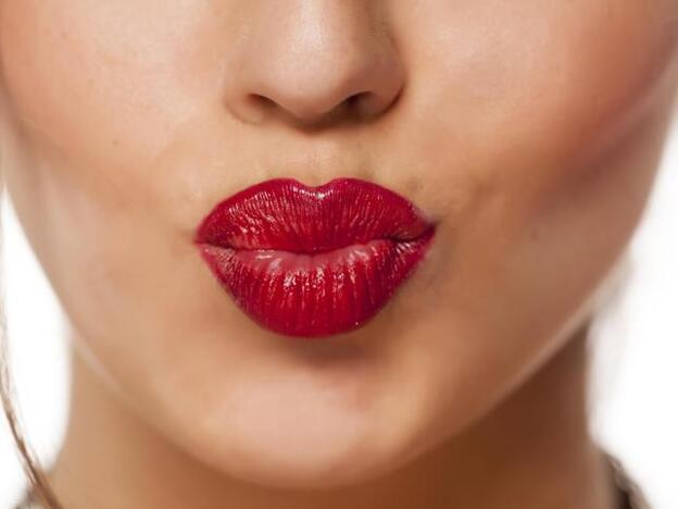 Una chica con los labios rojos./adobe stock