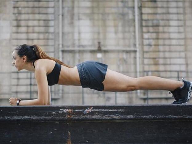 Una mujer practicando planchas, uno de los ejercicios más eficaces para trabajar las abdominales.
