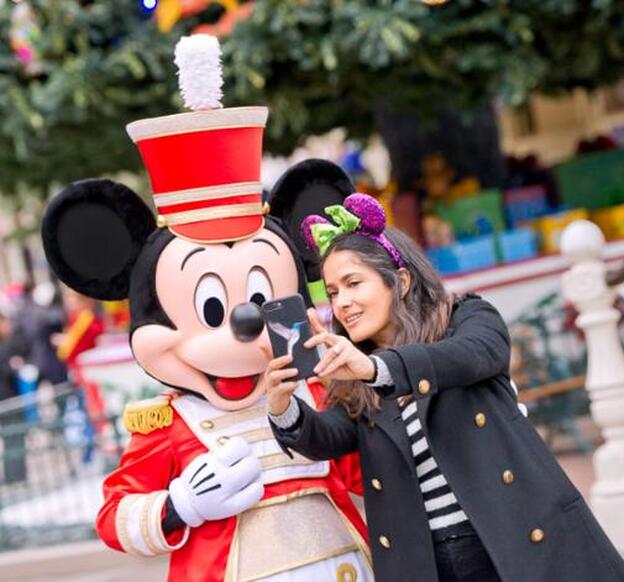 Salma Hayek haciéndose una foto junto a Mickey Mouse en Disneyland París.