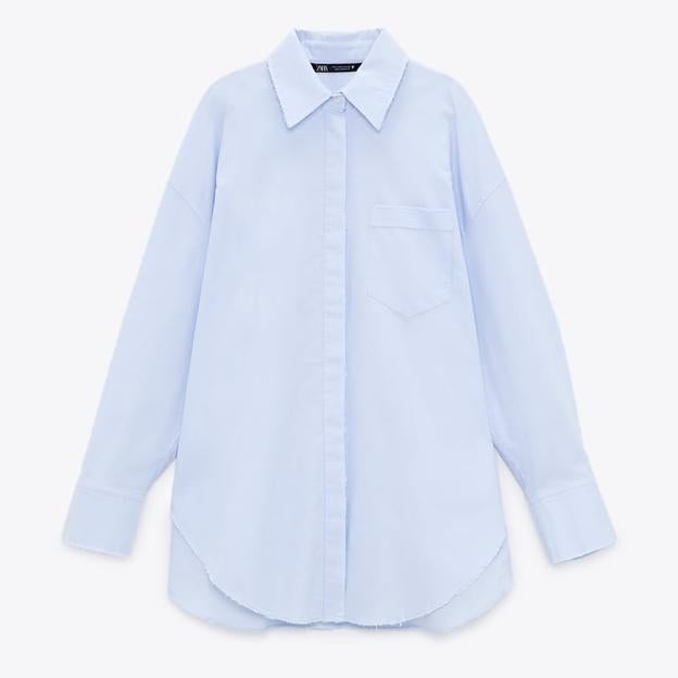 Camisa azul de estilo masculino con el bajo deshilachado de Zara.