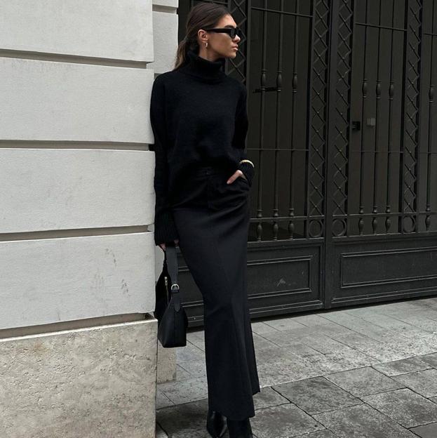 La influencer lleva un total look black con falda negra/@SPODENKIMOJE