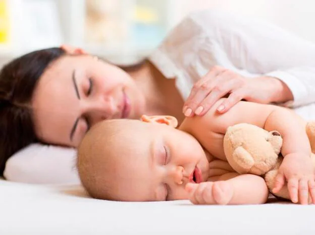 Madre durmiendo junto a su bebé/Fotolia