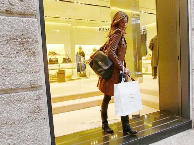 Una mujer, saliendo de una tienda de Prada./GETTY