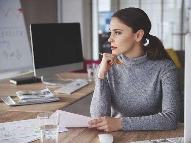 Una mujer, pensativa en el trabajo./FOTOLIA