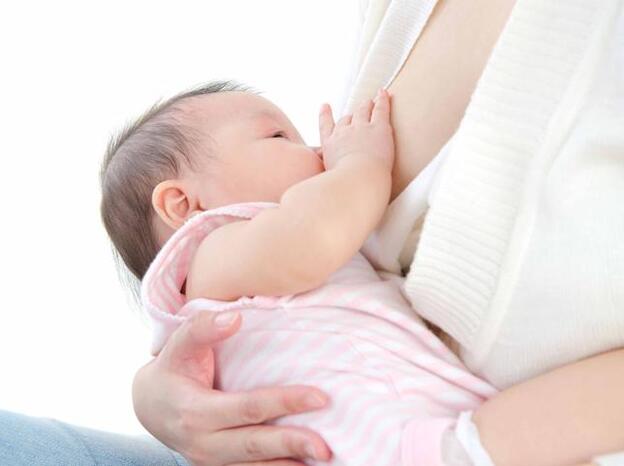 Una mujer alimentando a su bebé./adobe stock