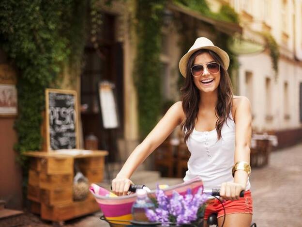 Una mujer, paseando con su bici./gtres