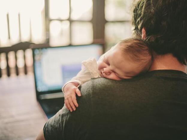 Un bebé descansa sobre el hombro de su padre./getty images