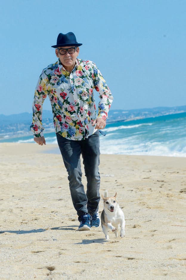 José Corbacho pasea a su perro por la playa.