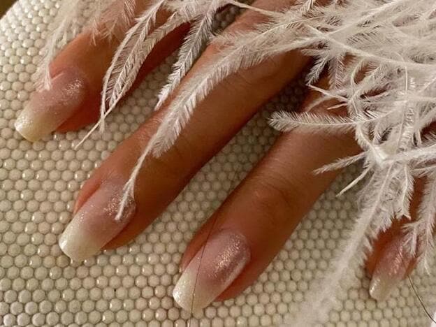 Jennifer Lopez apostó por una sencilla manicura francesa con un toque de brillo.