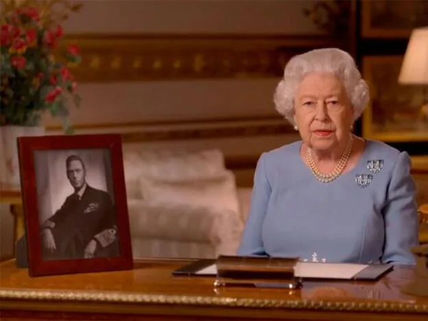 La reina Isabel II durante su discurso desde Windsor, con una foto de su padre, el reu Jorge VI, sobre el escritorio. Pincha sobre la foto para ver la vida de la monarca en imágenes./dr.