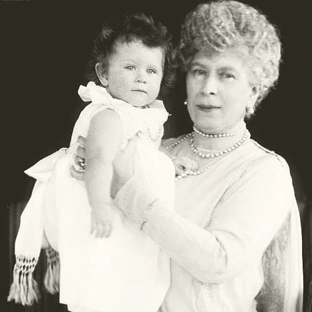 La reina Isabel II de bebé, en brazos de su abuela la reina María.