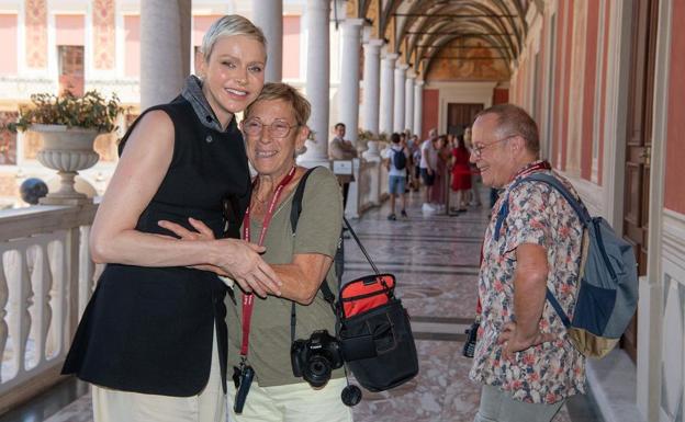 La princesa Charléne abraza a una turista a la que guió por las instalaciones restauradas del palacio Grimaldi. 