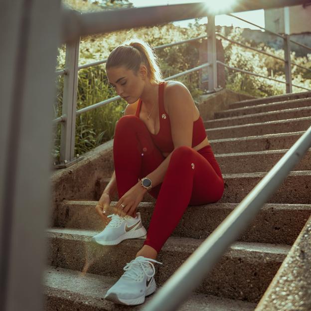 Mujer abrochándose las zapatillas para hacer running. 