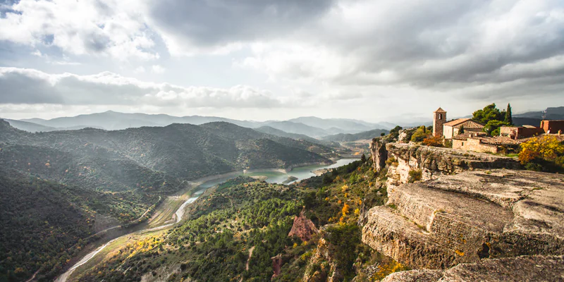 A majestic view over the mountain village of Siurana, taken from the famous Salto de la Reina Mora, with views of the dam in the valley below./