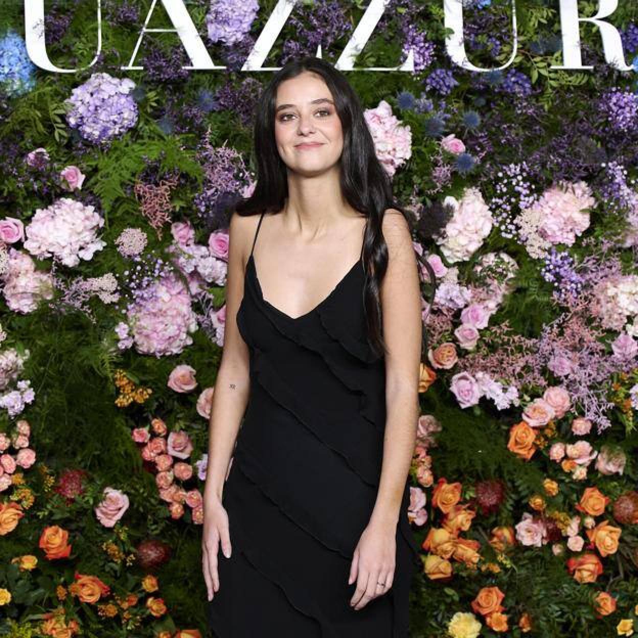 Victoria Federica en uno de sus últimos eventos, con un vestido negro de tirantes y frente a una pared de flores. /getty images