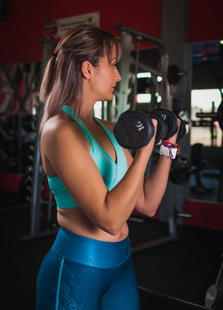 Mujer entrenando con pesas/PEXELS