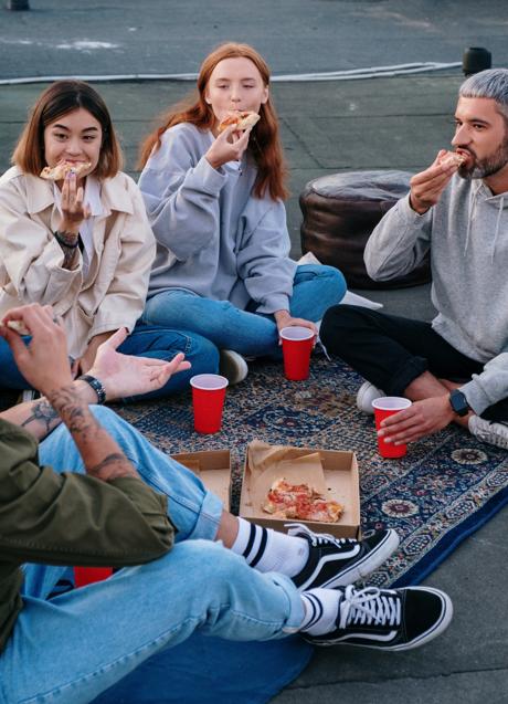 Group of friends eating pizza/PEXELS