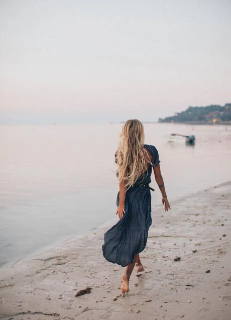 Woman walking on the beach/PEXELS