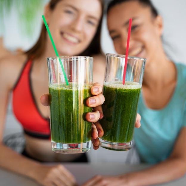 Dos mujeres tomando zumos verdes. 