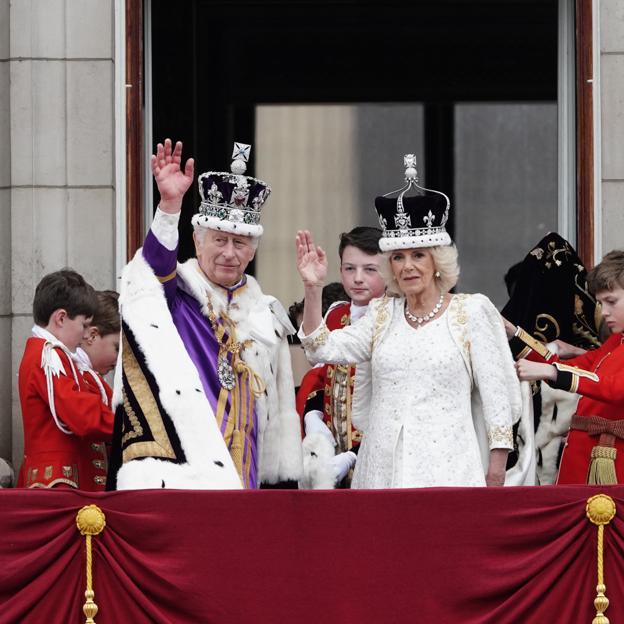 Los reyes Carlos y Camilla saludan desde el balcón de Buckingham Palace. /