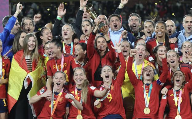 La reina Letizia y la infanta Sofía, en medio de la celebración de la selección española de fútbol femenino, con el trofeo en la mano y la bandera sobre los hombros. 