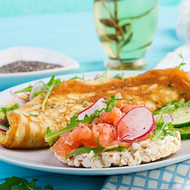 Plato con tortilla, salmón, verduras de hoja verde... 