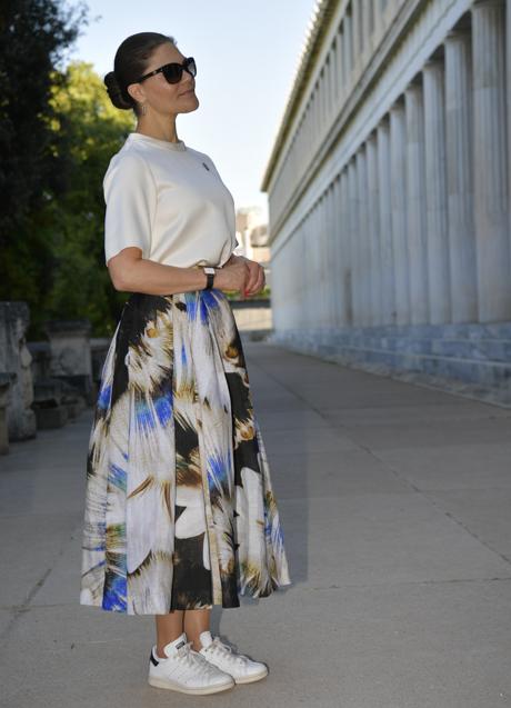 Victoria de Suecia con camisa satinada, falda con estampado de flores y zapatillas.