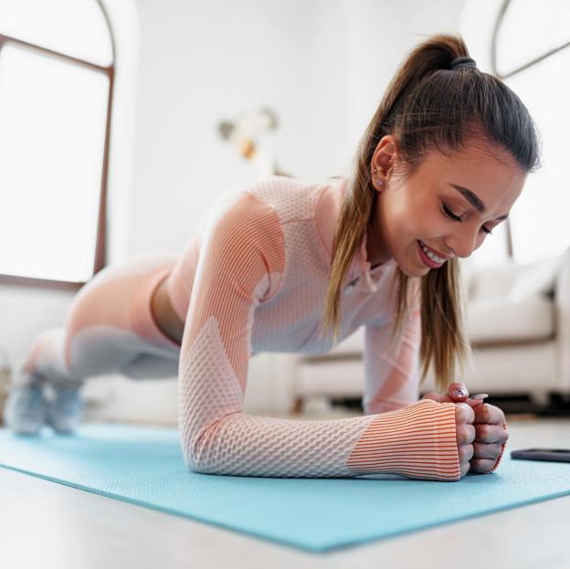 Mujer deportista realizando una plancha de antebrazos. 