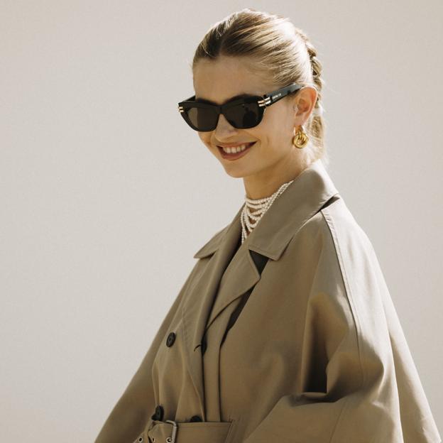 Mujer con gabardina y collar de perlas