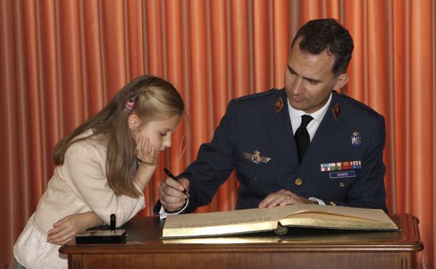 La princesa Leonor observa cómo su padre firma en el libro de autoridades de la Academia Militar del Aire de San Javier, en 2014. 