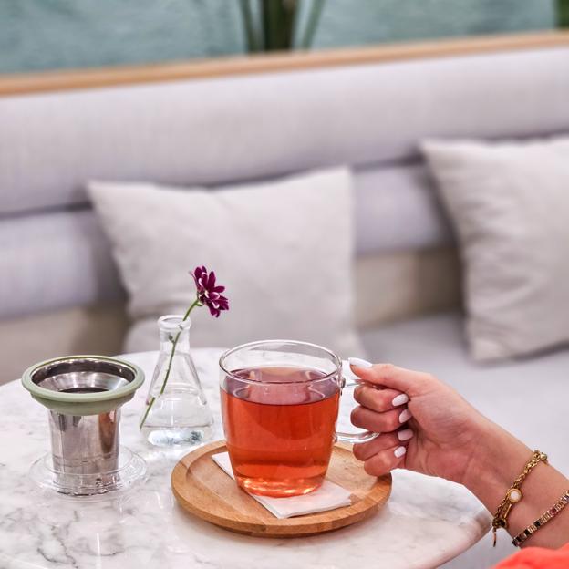 Mujer sosteniendo una taza de infusión. 