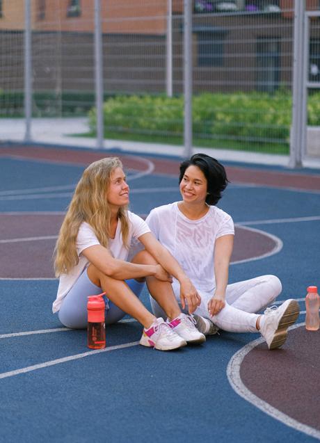 Mujeres sentadas con botellas de agua y ropa deportiva/PEXLES