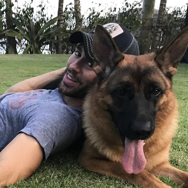 Enrique Iglesias en una foto reciente, en el jardín de su casa de Miami y con uno de sus perros. 