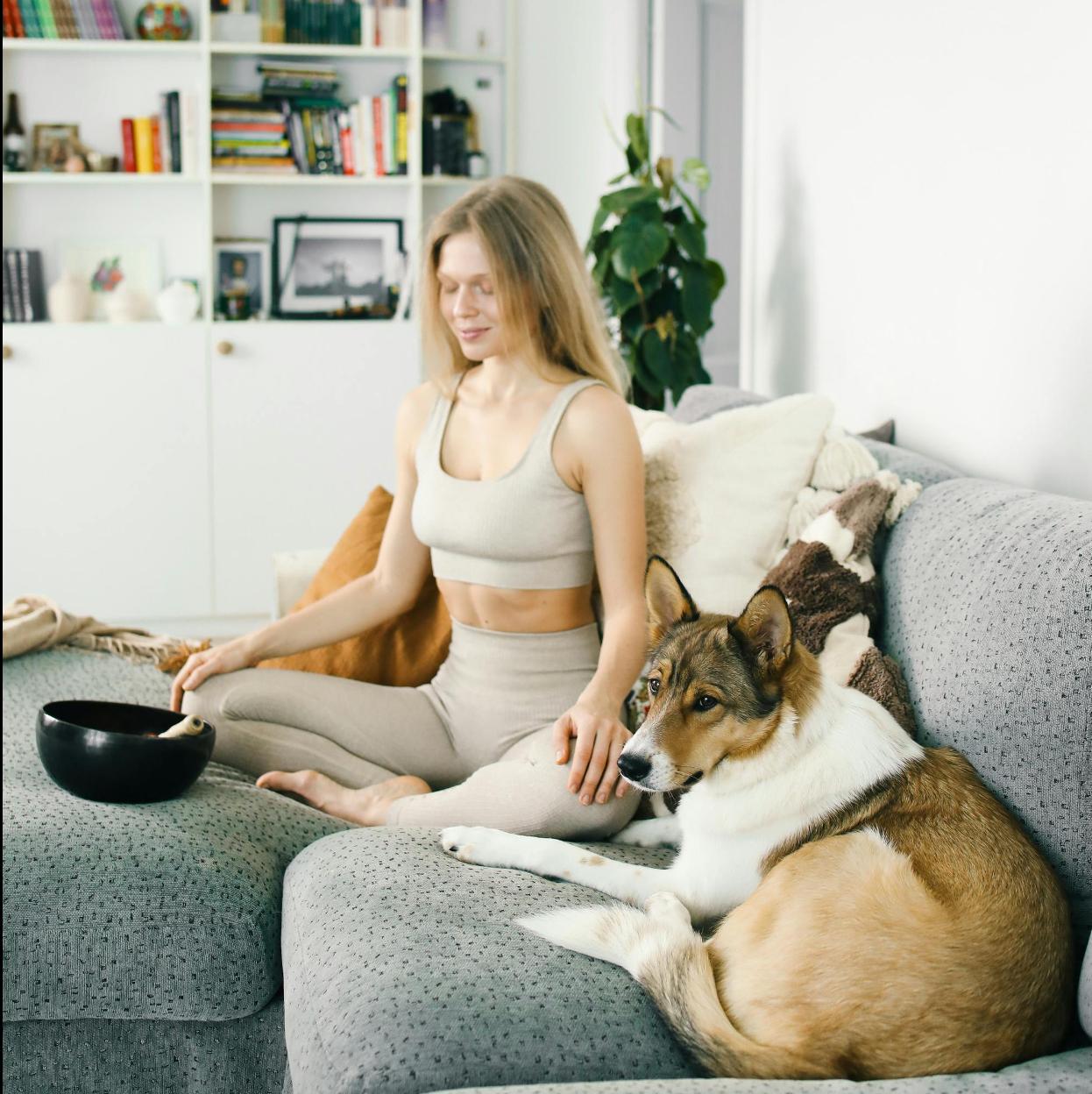 Mujer meditando en casa con su mascota. //PEXELS