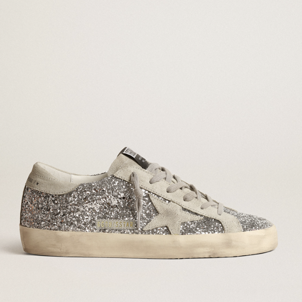 Zapatillas Super-Star con purpurina plateada y estrella de ante en gris de Golden Goose (520 euros).