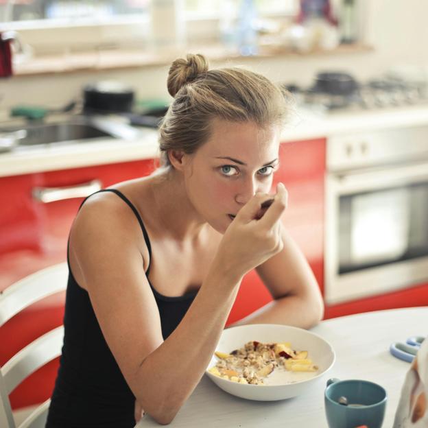 Mujer tomando un desayuno saludable. 