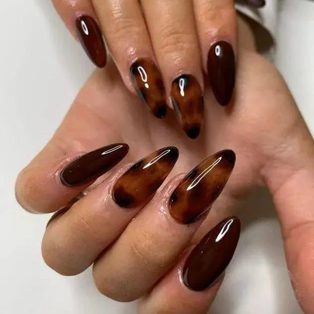 Manicura marrón oscuro combinada con uñas tortoise