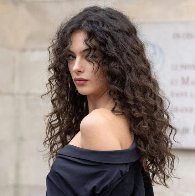 Deva Cassel con corte de pelo rizado largo estilo mariposa