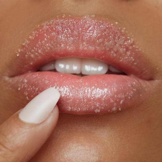 Mujer usando exfoliante de labios