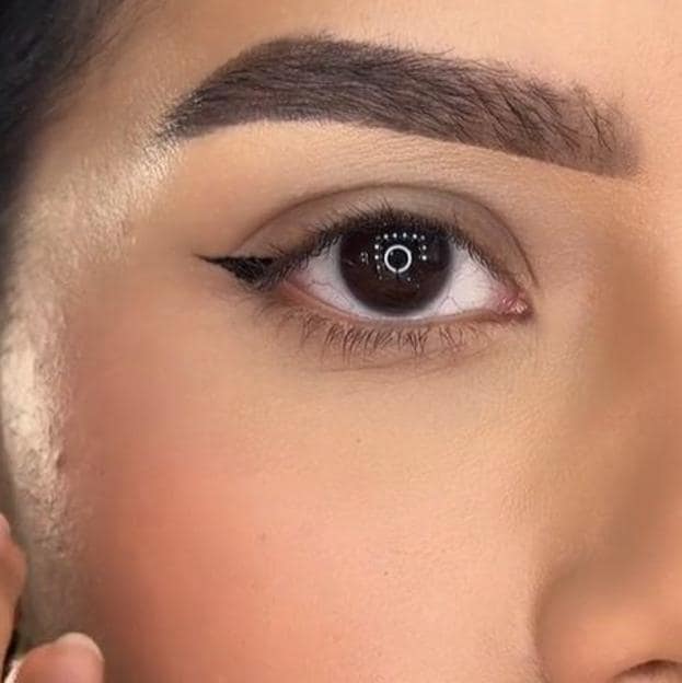 Influencer haciendo eyeliner tilde para párpado caído