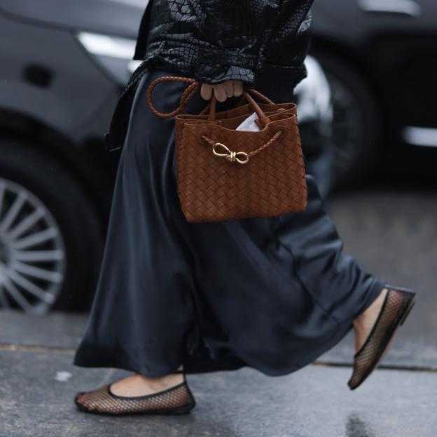 Una mujer con bolso trenzado.