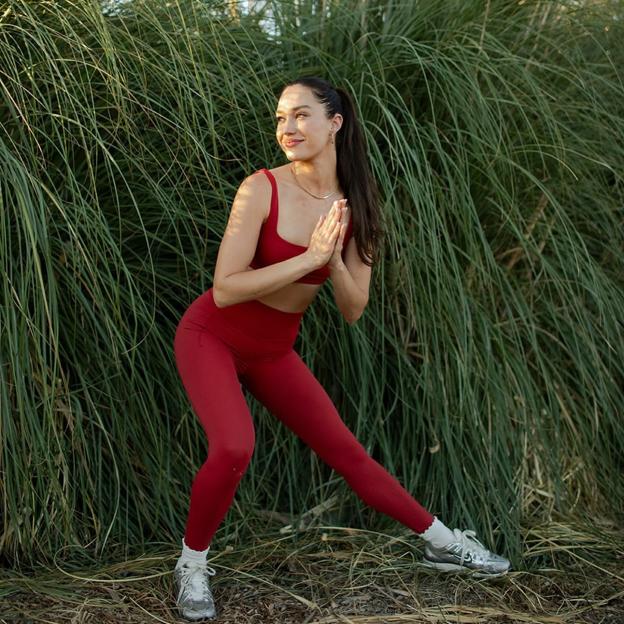 Mujer haciendo posturas de yoga al aire libre. 