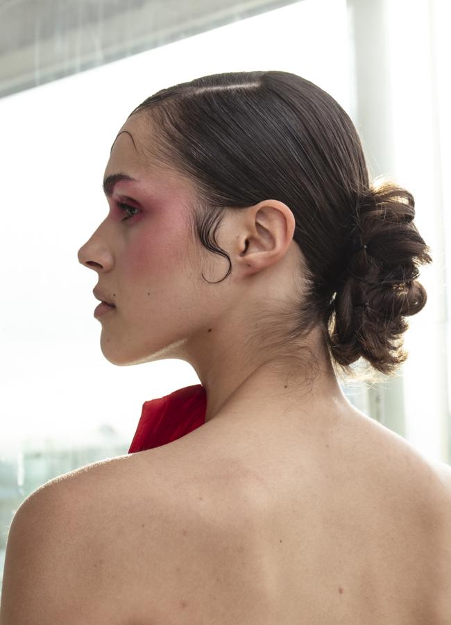 Una modelo con recogido pulido y baby hairs apra el desfile de Serra Studio. Foto: Kristen Wicce.